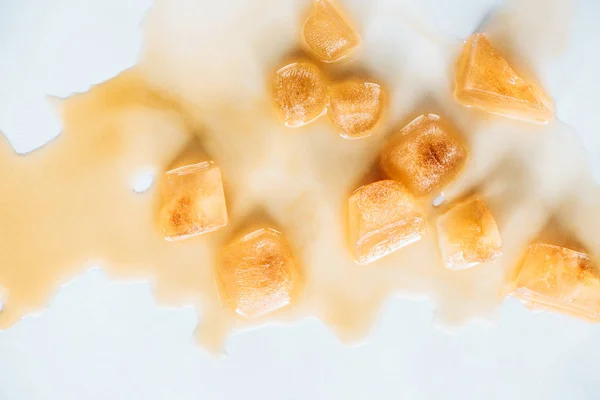 Vue de dessus de glaçons bruns en café sur plateau blanc — Photo de stock