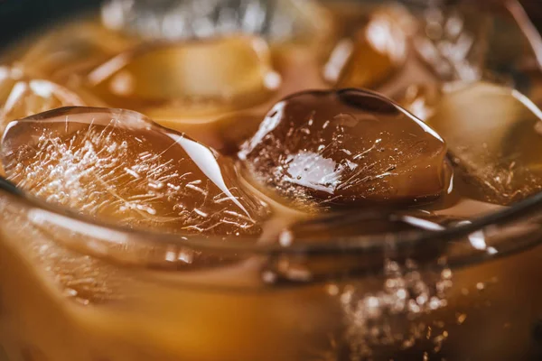 Vista ravvicinata dei cubetti di ghiaccio nel caffè freddo preparato in vetro — Foto stock