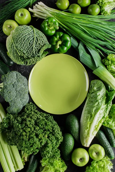 Vista superior del plato verde entre verduras verdes, concepto de alimentación saludable - foto de stock