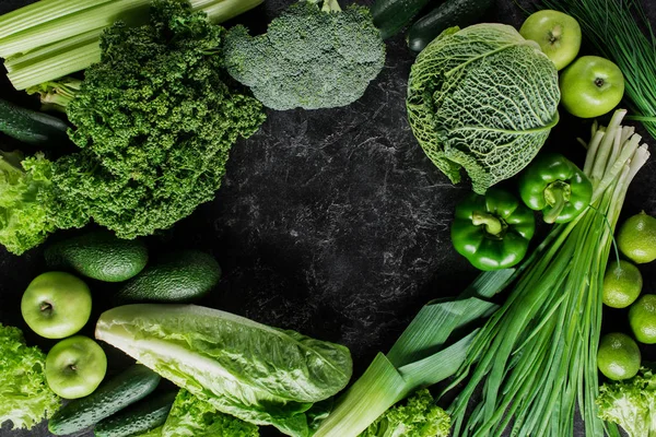 Vista superior de las verduras verdes en la mesa de hormigón oscuro, concepto de alimentación saludable - foto de stock