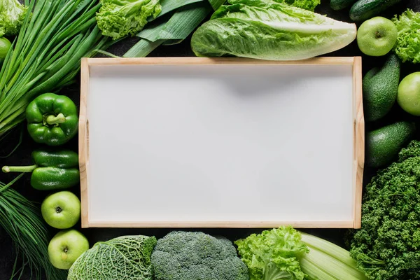 Vista dall'alto del vassoio vuoto tra verdure verdi, concetto di alimentazione sana — Foto stock