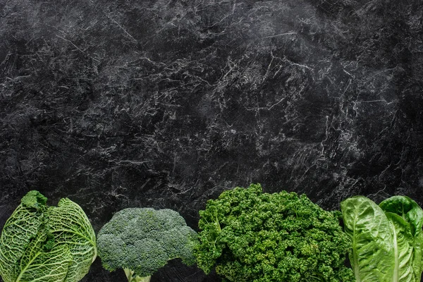 Top view of broccoli, savoy cabbage and parsley on concrete table, healthy eating concept — Stock Photo