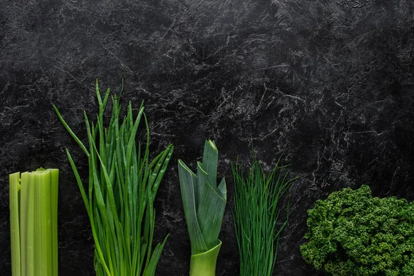 Vista superior de cebolla verde, puerro y perejil sobre mesa de hormigón, concepto de alimentación saludable - foto de stock