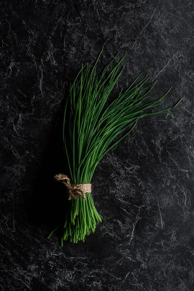 Vista dall'alto di mazzo di erba cipollina su tavolo di cemento, concetto di alimentazione sana — Foto stock