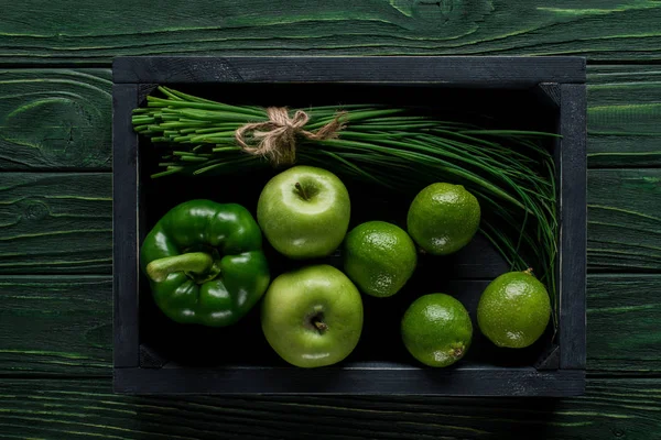 Vista superior de legumes e frutas verdes em caixa de madeira na mesa, conceito de alimentação saudável — Fotografia de Stock