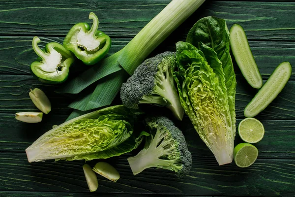 Top view of green vegetables on wooden tabletop, healthy eating concept — Stock Photo