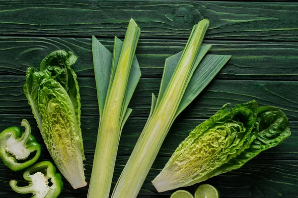 Top view of green leek, cabbage and bell peppers on wooden table, healthy eating concept — Stock Photo