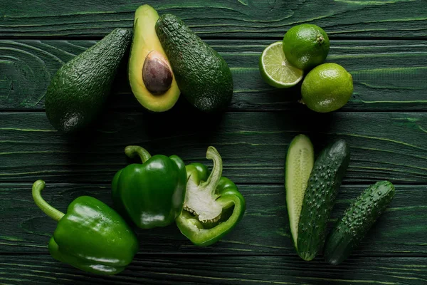 Top view of cut green vegetables and fruit on wooden table, healthy eating concept — Stock Photo