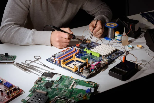 Engineer working with soldering equipment and motherboard — Stock Photo