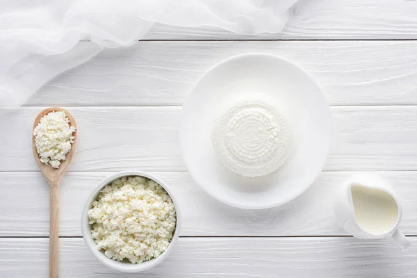 Vue du dessus du fromage cottage bio frais et du lait dans une cruche sur une table en bois — Photo de stock