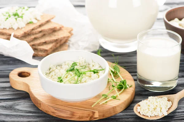 Крупный план вкусного здорового творога и молока на деревянном столе — стоковое фото