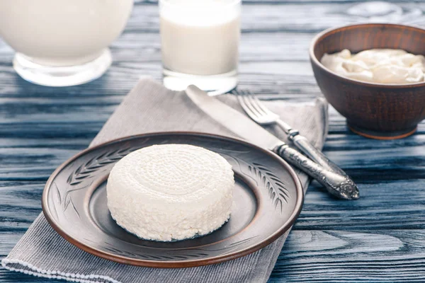 Frischer, gesunder Quark auf Teller, saure Sahne und Glas Milch auf Holztisch — Stockfoto