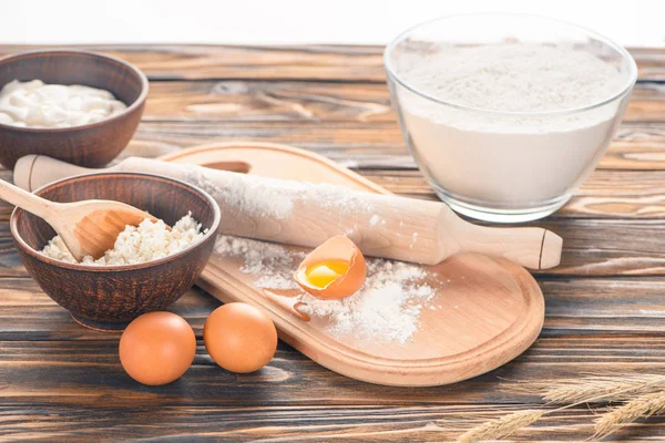 Nahaufnahme von Hüttenkäse, Eiern und Mehl auf Holztisch — Stockfoto