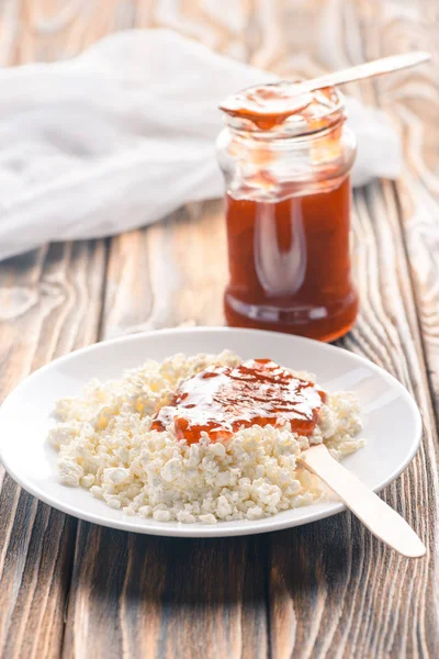 Close-up view of tasty healthy cottage cheese with jam on wooden table — Stock Photo