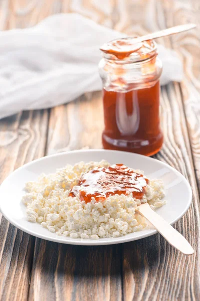 Крупный план вкусного здорового творога с джемом на деревянном столе — стоковое фото