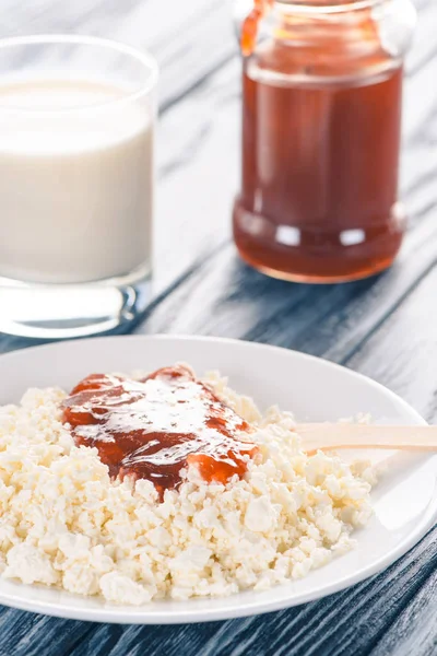 Close-up view of healthy cottage cheese with jam and glass of milk on table — Stock Photo