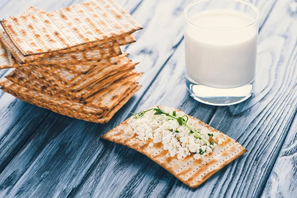 Vista de cerca de galletas saladas con requesón y vaso de leche sobre mesa de madera - foto de stock