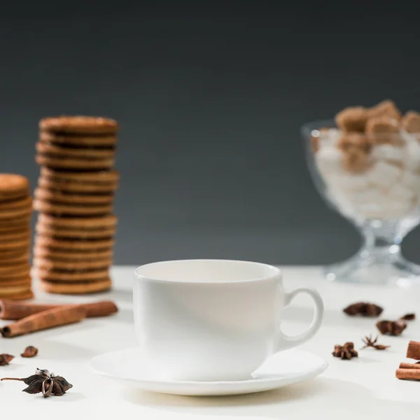 White cup for coffee on table with cookies and spices — Stock Photo