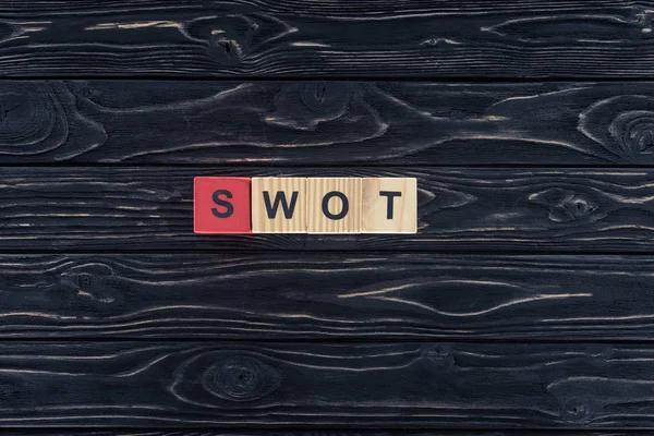 Top view of word swot made of wooden blocks on dark wooden tabletop — Stock Photo