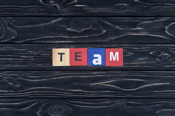 Ansicht von Wort-Team aus Holzklötzen auf dunkler Holztischplatte — Stockfoto