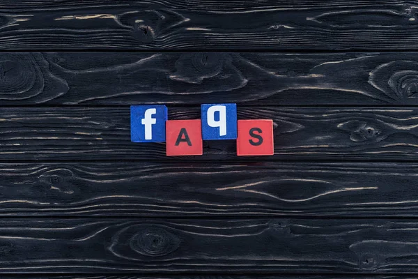 Top view of word faqs made of wooden blocks on dark wooden tabletop — Stock Photo