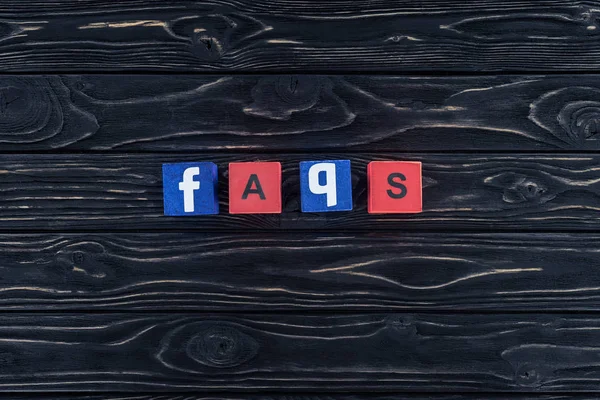 Top view of word faqs made of wooden blocks on dark wooden tabletop — Stock Photo