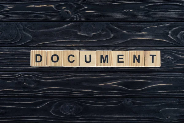 Top view of word document made of wooden blocks on dark wooden tabletop — Stock Photo