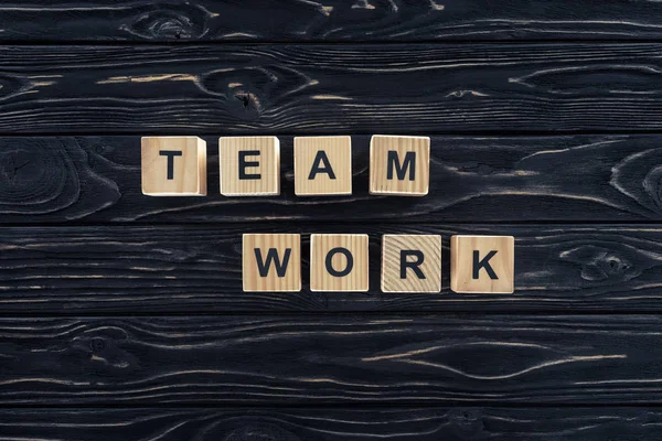 Top view of word team work made of wooden blocks on dark wooden tabletop — Stock Photo