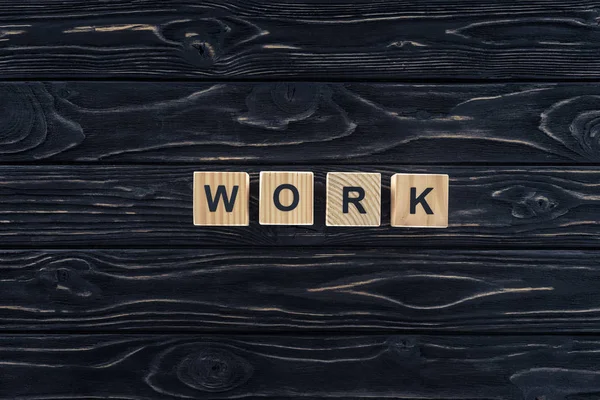 Top view of word work made of wooden blocks on dark wooden tabletop — Stock Photo