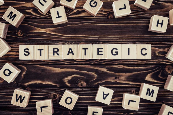 Top view of strategy inscription made of wooden blocks on brown wooden surface — Stock Photo