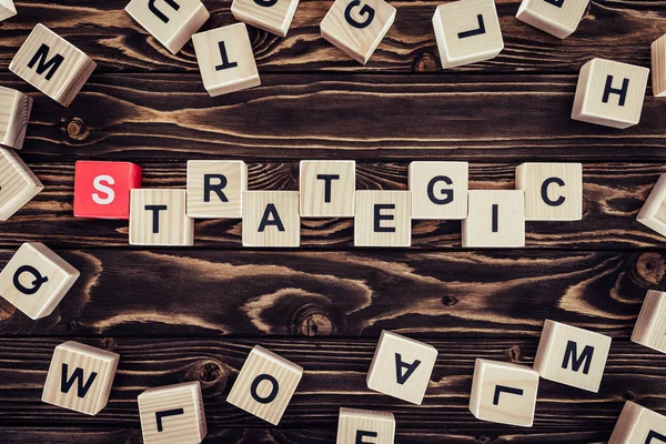 Top view of strategy inscription made of wooden blocks on brown wooden surface — Stock Photo