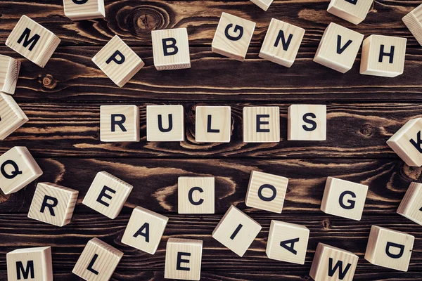 Top view of rules word made of wooden blocks on brown surface — Stock Photo