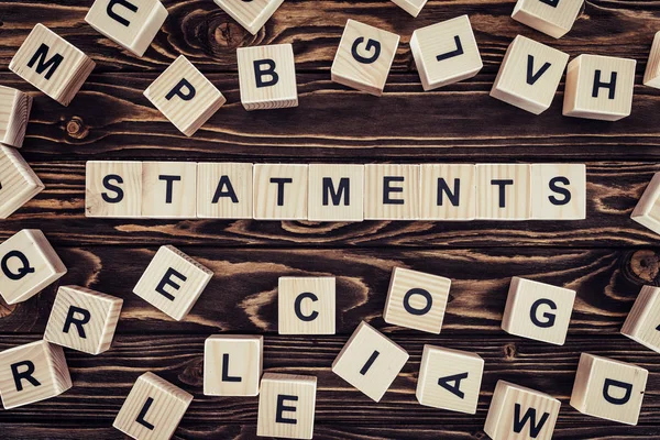 Vista superior de declaraciones de palabras hechas de bloques de madera en la superficie de madera - foto de stock