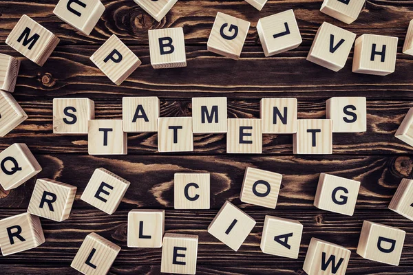 Top view of of word statements made of wooden blocks on wooden surface — Stock Photo