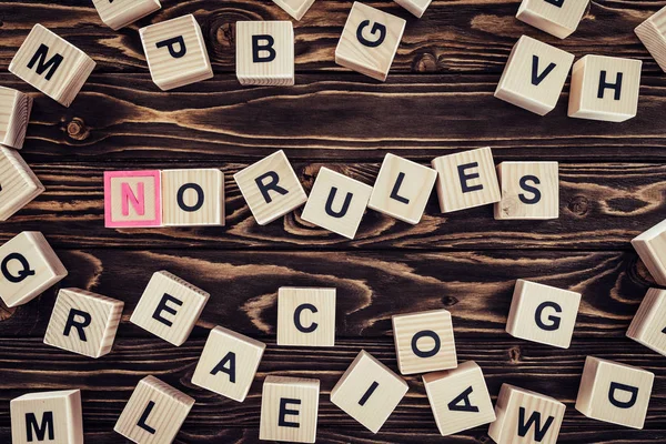 Top view of no rules lettering made of wooden cubes on brown wooden tabletop — Stock Photo