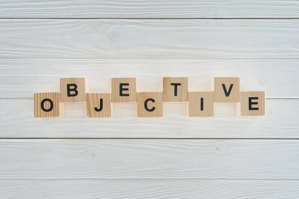 Top view of objective word made of blocks on white wooden surface — Stock Photo