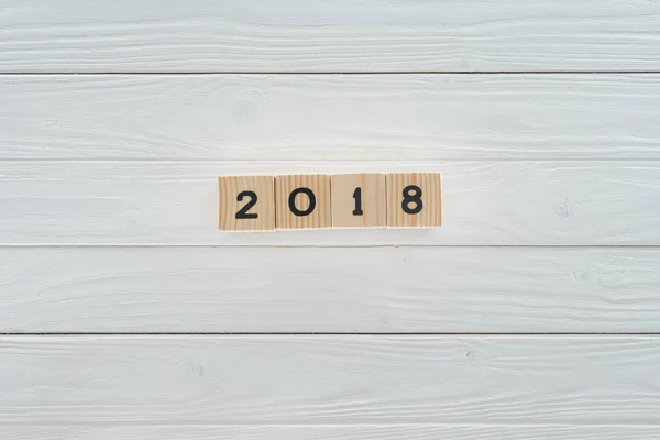 Vista dall'alto di blocchi di legno disposti nel 2018 su un tavolo di legno bianco — Foto stock