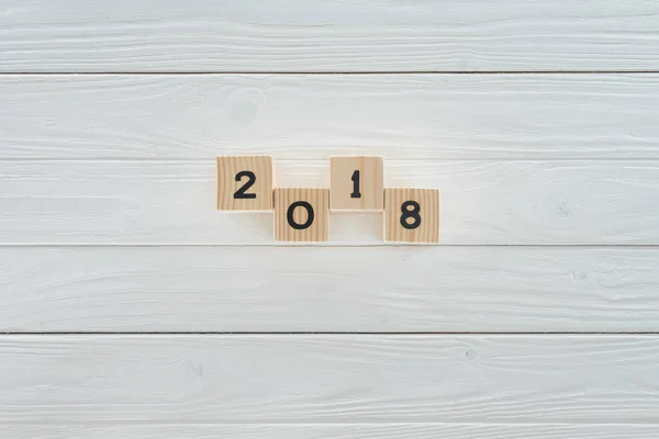 Top view of wooden blocks arranged in 2018 on white wooden tabletop — Stock Photo