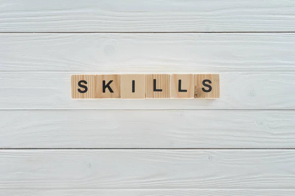 Top view of skills inscription made of blocks on white wooden surface — Stock Photo