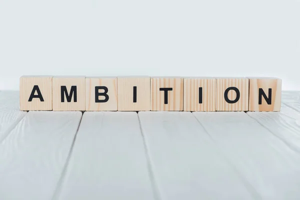 Close up view of ambition word made of wooden cubes on white wooden tabletop — Stock Photo