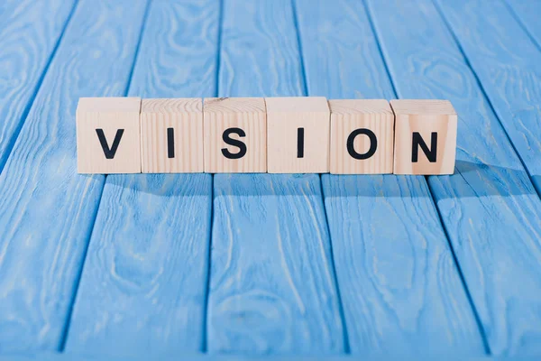 Close up view of vision word made of wooden blocks on blue tabletop — Stock Photo