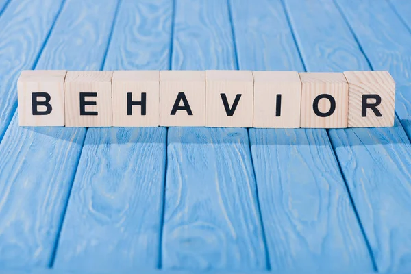 Close up view of behavior word made of wooden blocks on blue tabletop — Stock Photo
