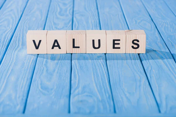 Vista ravvicinata dei valori parola fatta di blocchi di legno su un tavolo blu — Foto stock