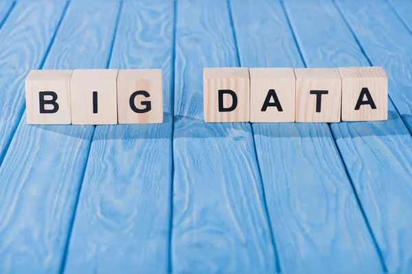 Close up view of arranged wooden blocks into big data phrase on blue wooden surface — Stock Photo
