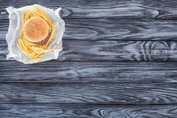 Vista superior de hambúrguer com batatas fritas na mesa de madeira — Fotografia de Stock