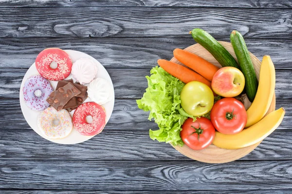 Top view of fresh fruits with vegetables and sweets on wooden table — Stock Photo