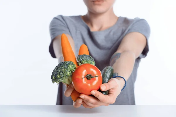 Vista de cerca de la mujer sosteniendo verduras frescas maduras - foto de stock