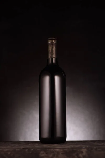 Single bottle of luxury red wine on black — Stock Photo