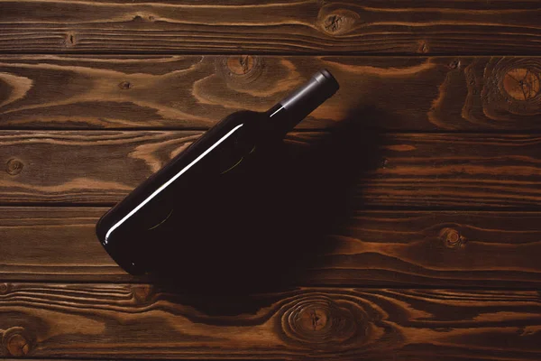 Vista dall'alto della bottiglia di vino rosso sul tavolo di legno — Foto stock