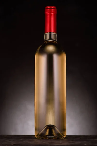 Single bottle of luxury white wine on black — Stock Photo
